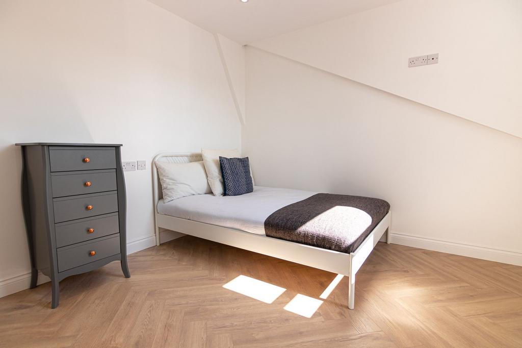 A bright and tidy single bedroom featuring a co...