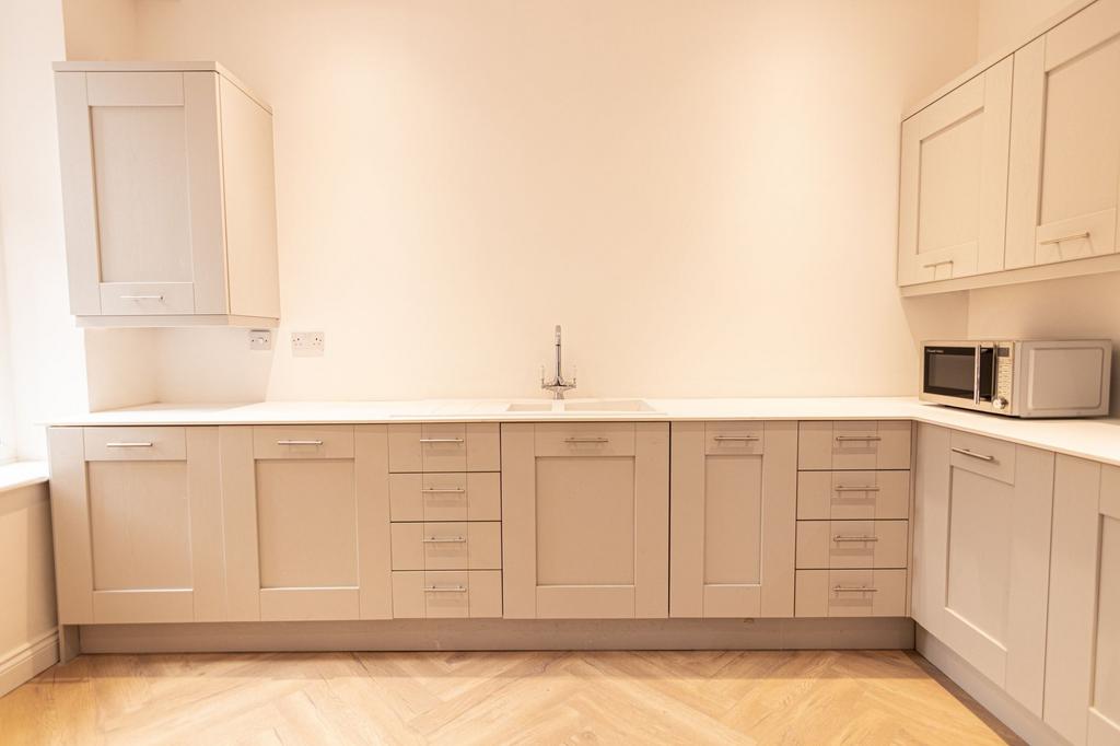 A clean and modern kitchen with neutral-colored...