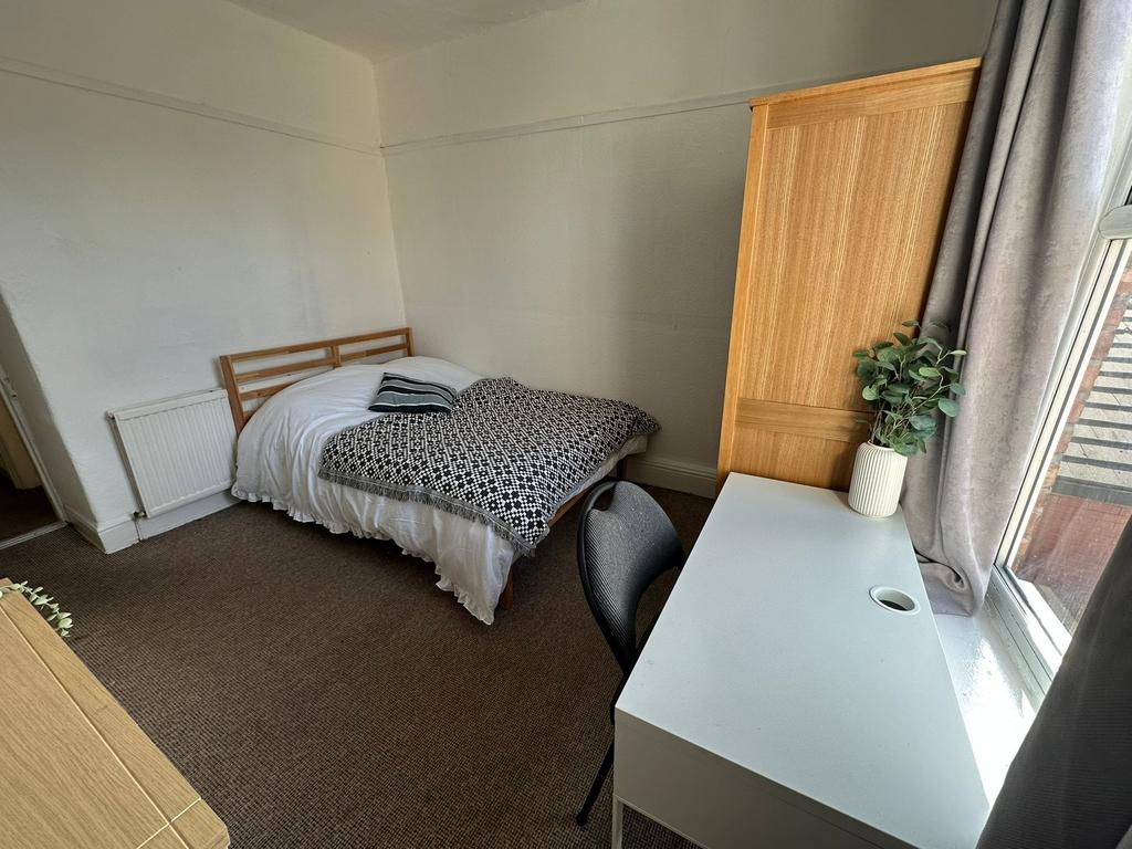 A cozy single bedroom featuring a comfortable b...