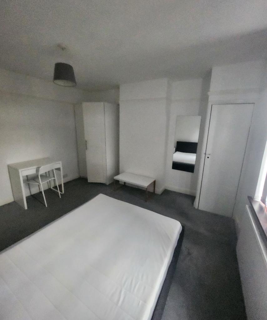 A minimalist bedroom with a clean, white bed an...