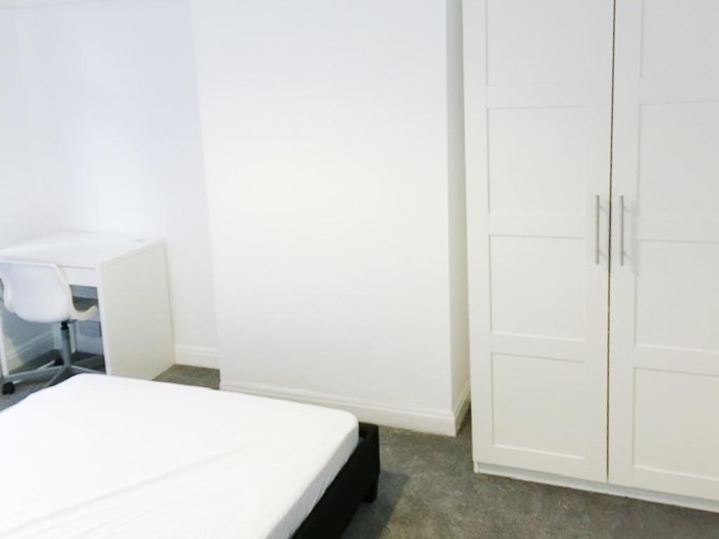 Bright, clean bedroom with neutral decor, a war...