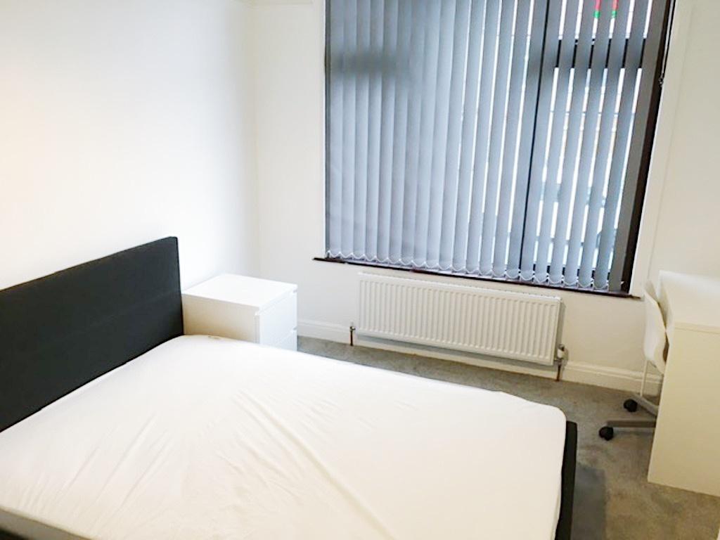 Bright, simply furnished bedroom with a double ...