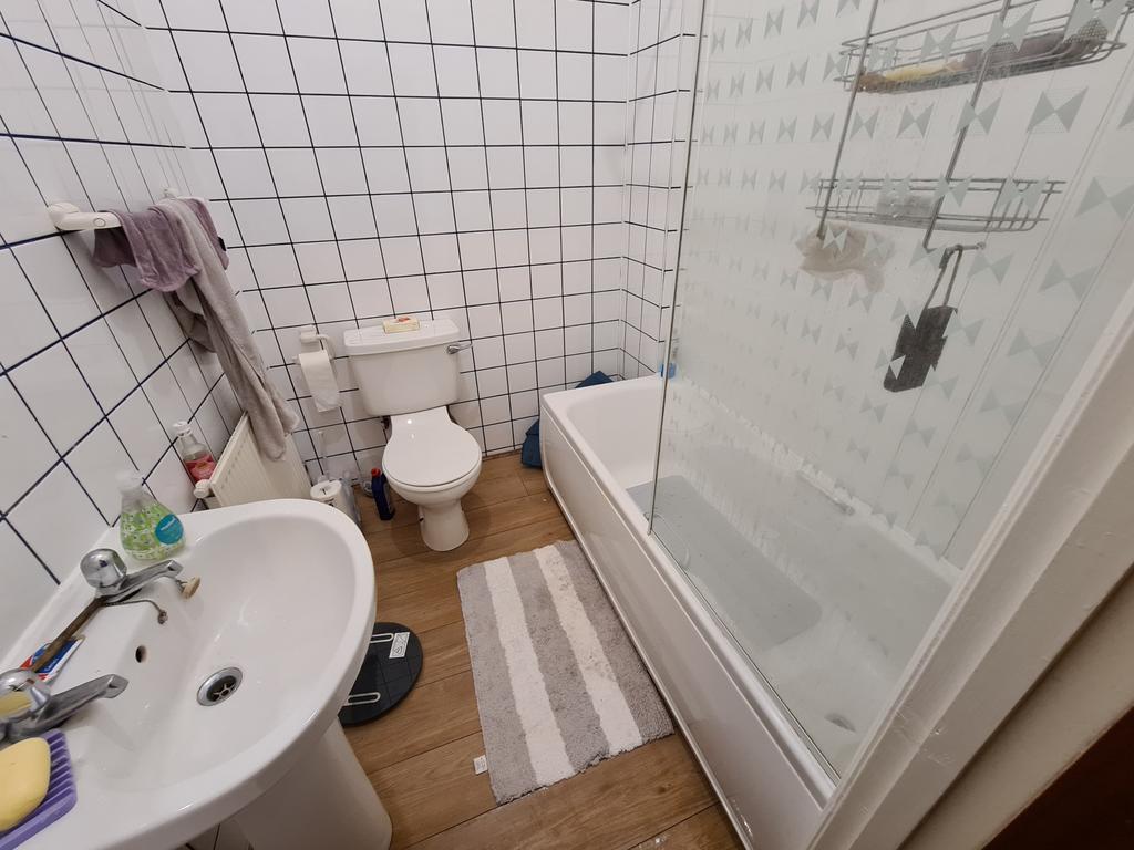 A spacious bathroom featuring a bathtub, toilet...