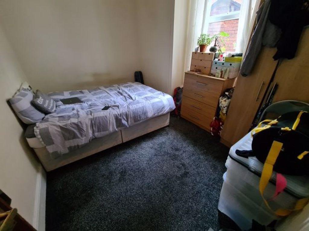 A cozy bedroom featuring a single bed with a pa...