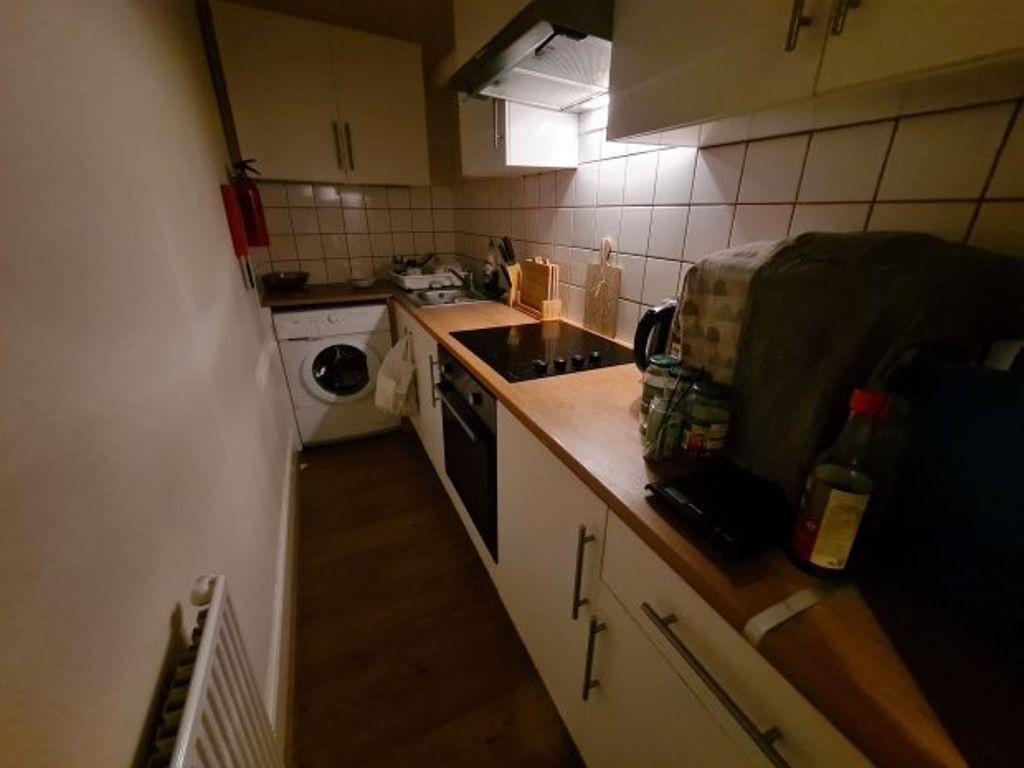 A compact kitchen area featuring essential appl...