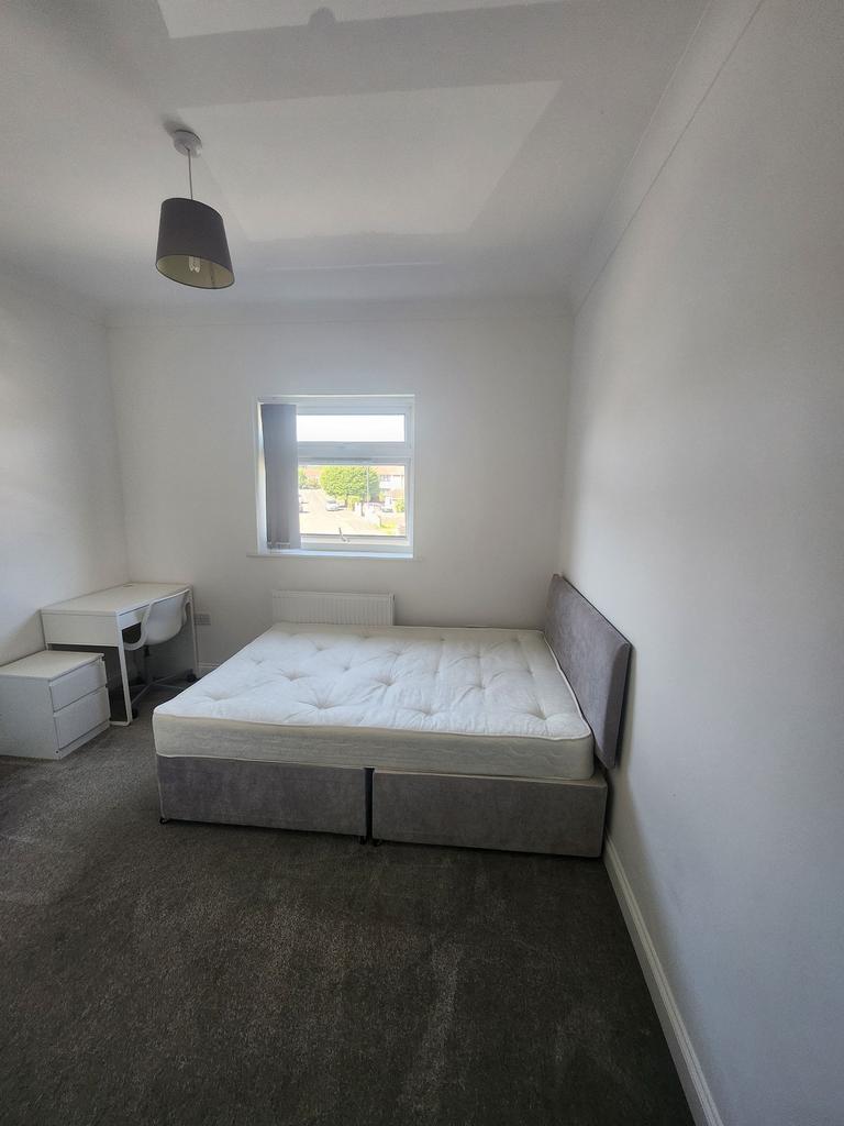A well-lit, tidy double bedroom featuring a com...
