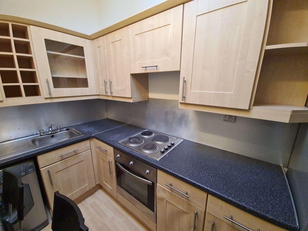 A modern kitchen featuring ample wooden cabinet...