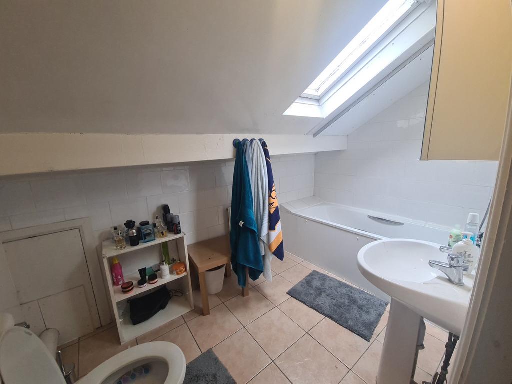 A bright and clean bathroom with a skylight win...
