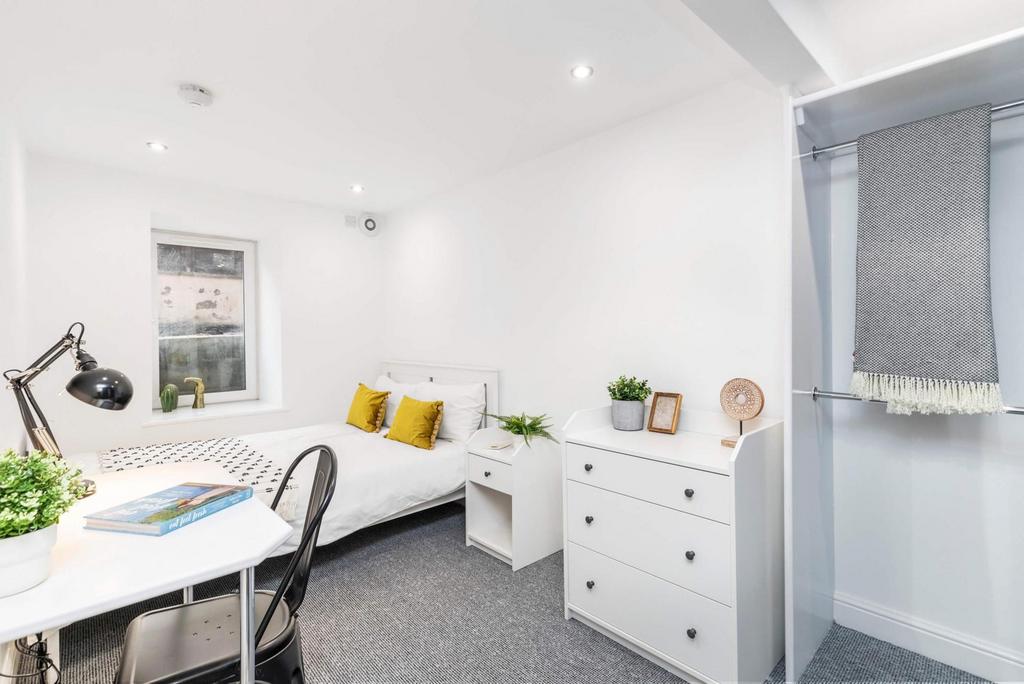 A bright and welcoming bedroom featuring a sing...