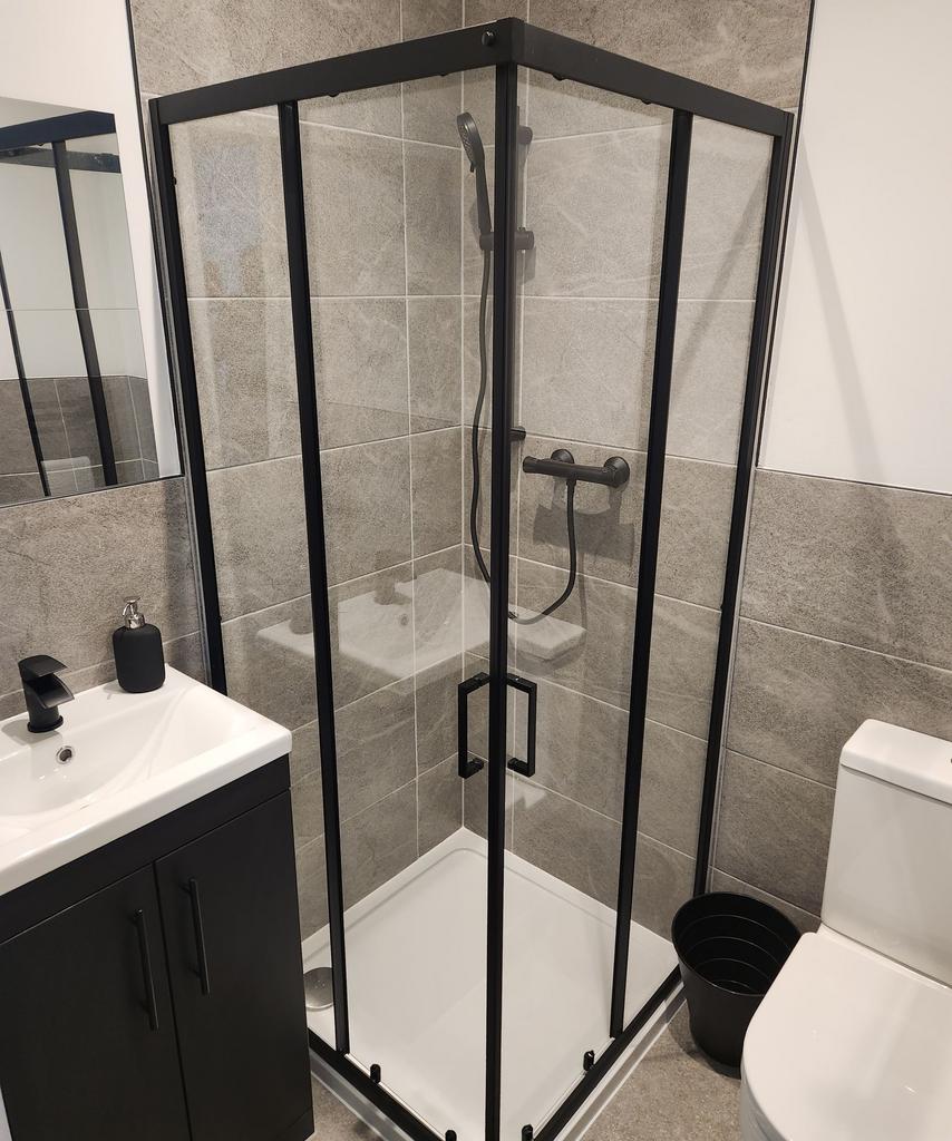 Modern bathroom featuring a spacious shower enc...
