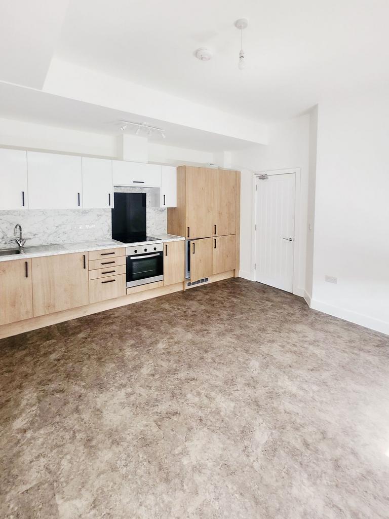 Bright, modern open-plan kitchen with light woo...