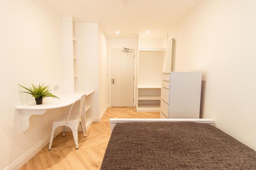 A bright and well-maintained bedroom featuring ...