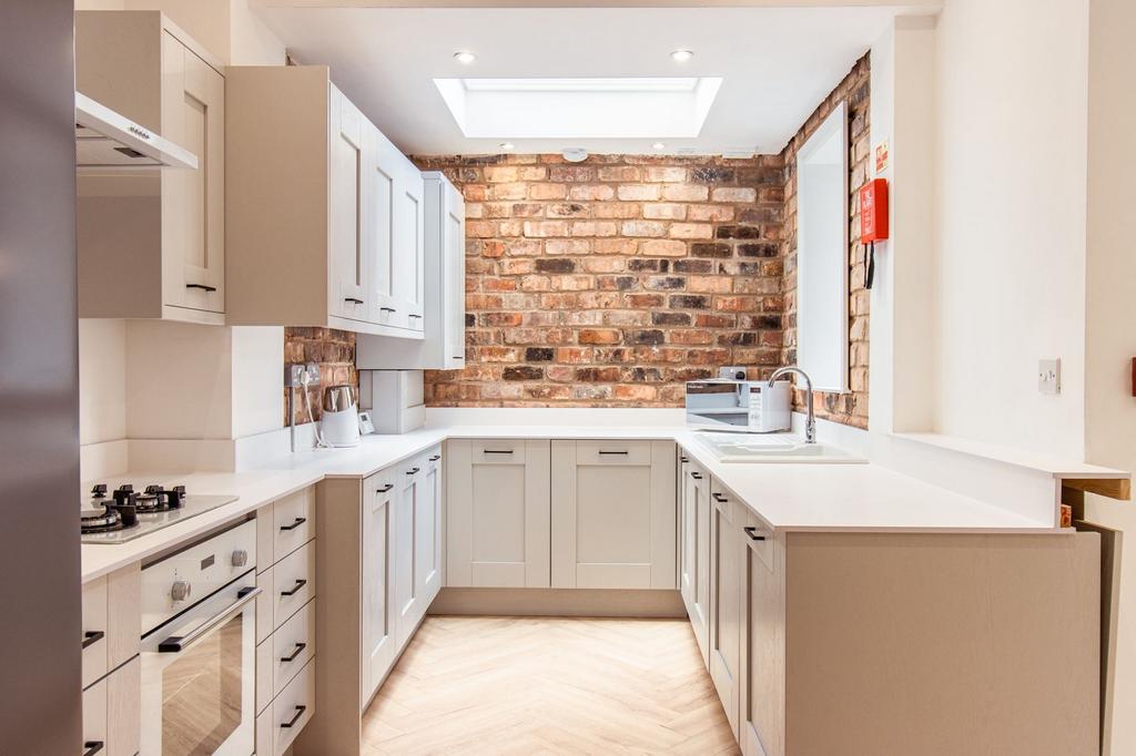Bright and modern kitchen featuring white cabin...