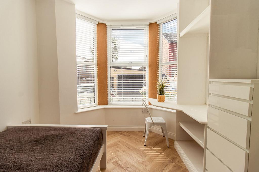 Bright and airy bedroom featuring large windows...