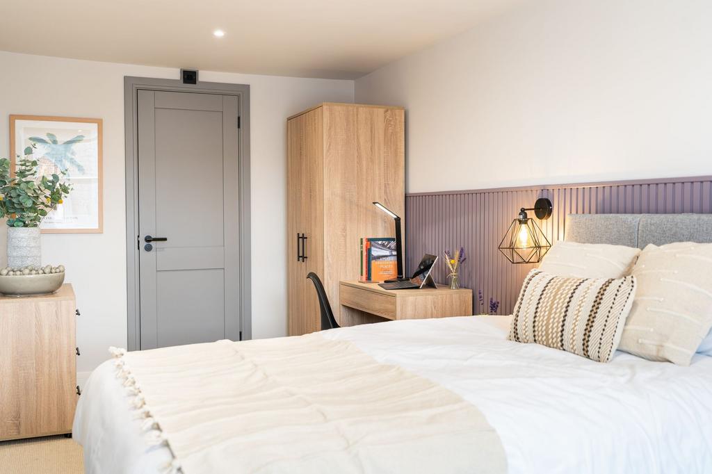 A bright and inviting bedroom featuring a large...