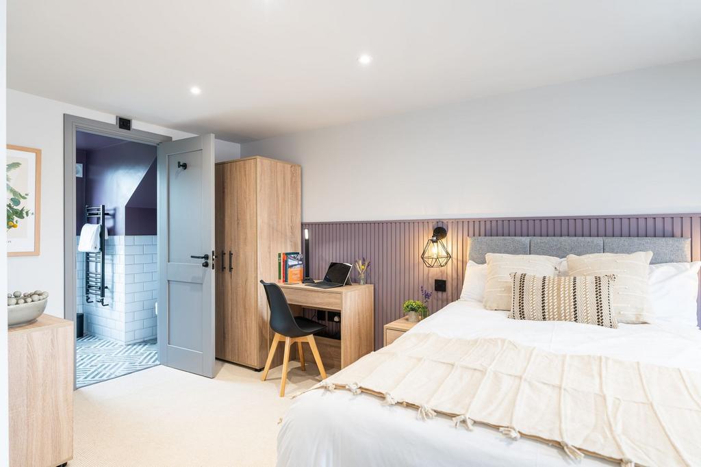 Bright and stylish master bedroom featuring a l...