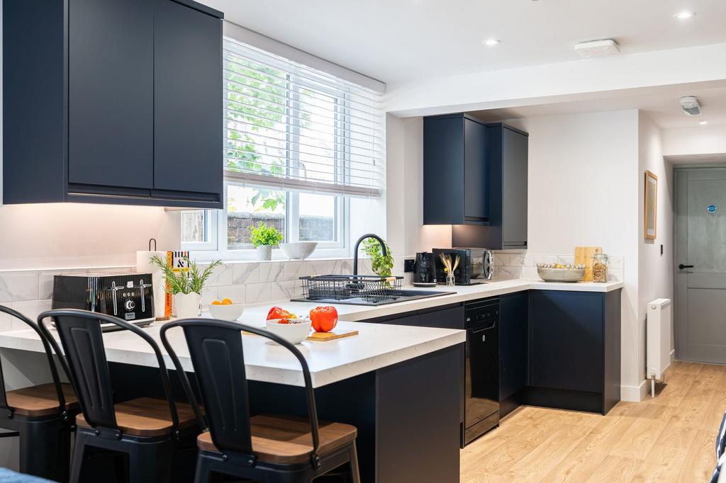 Modern and sleek kitchen featuring dark cabinet...