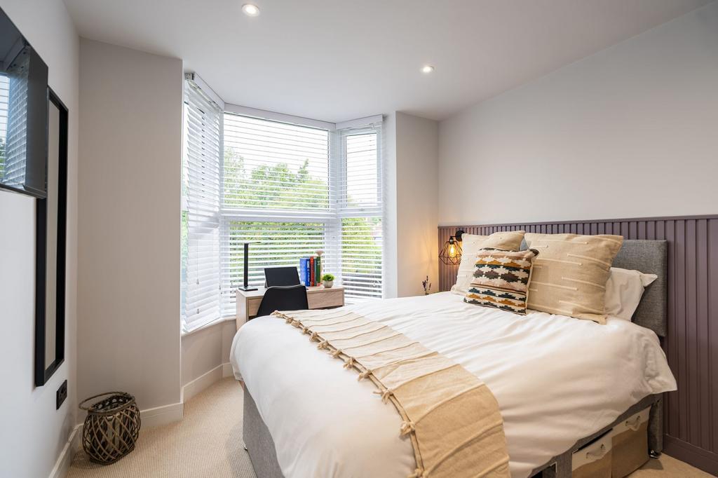 Bright and contemporary master bedroom featurin...