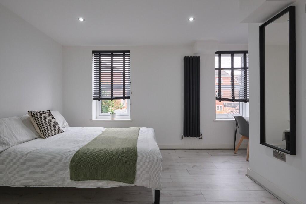 Bright and spacious bedroom featuring a large b...