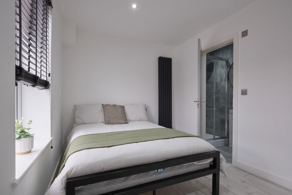 A bright and modern double bedroom featuring a ...