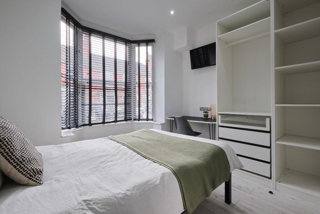 A modern and well-lit bedroom featuring a doubl...