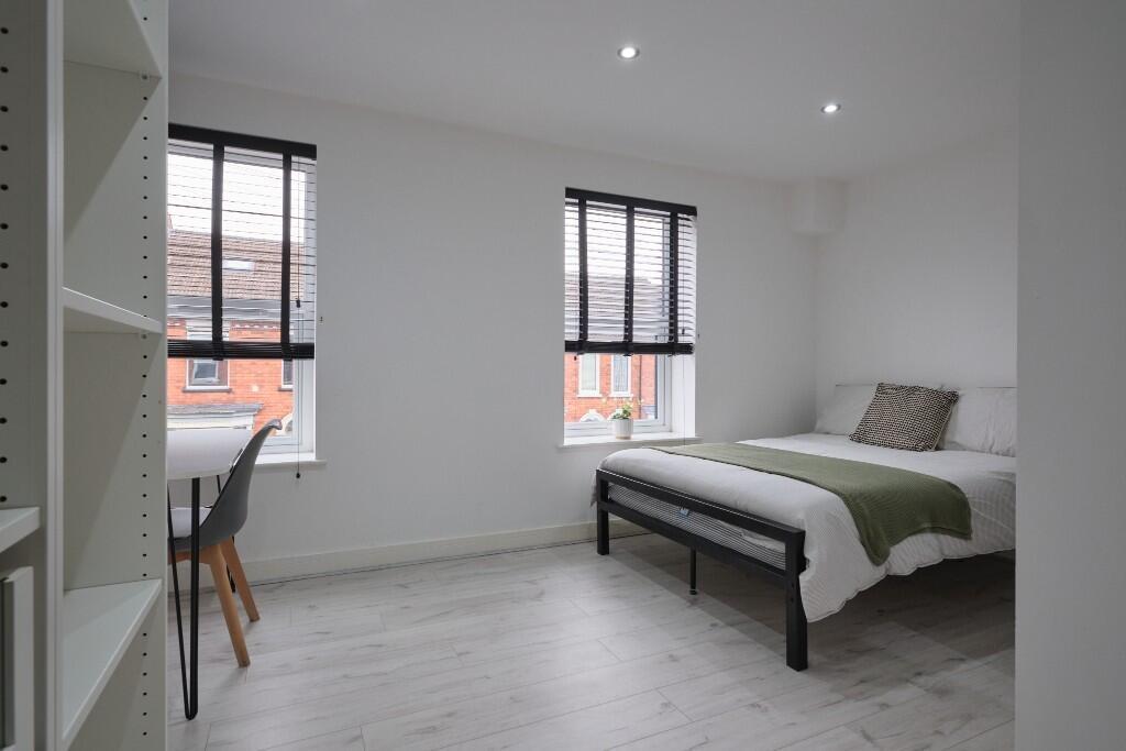 Bright, spacious master bedroom featuring two l...