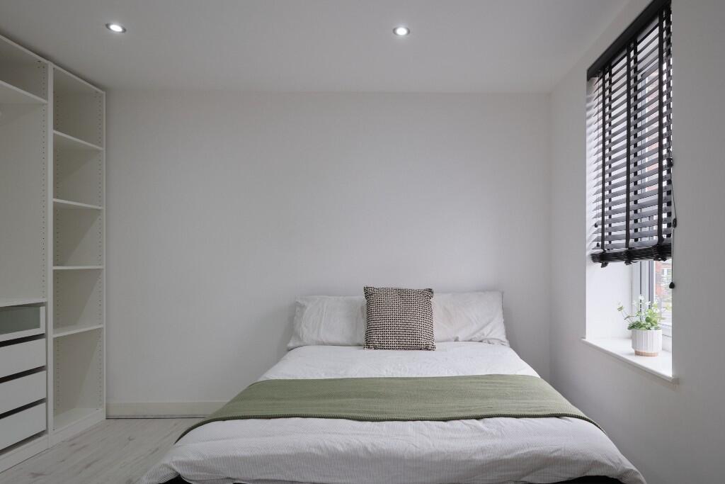 A spacious and bright master bedroom featuring ...