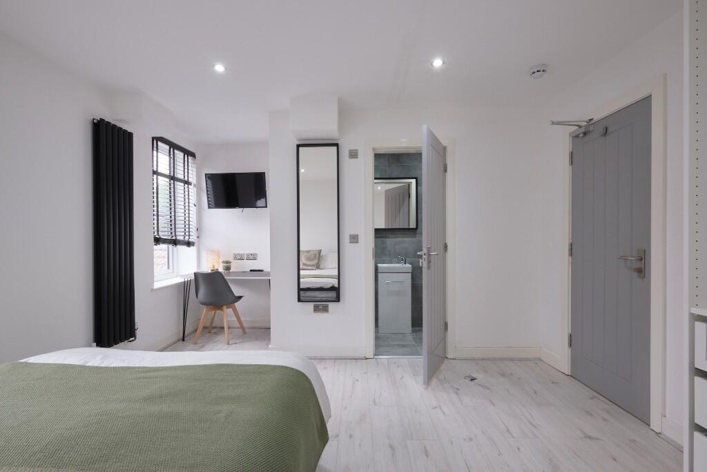 Bright, modern double bedroom with clean white ...