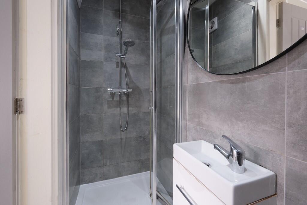 A clean and modern bathroom with a spacious sho...