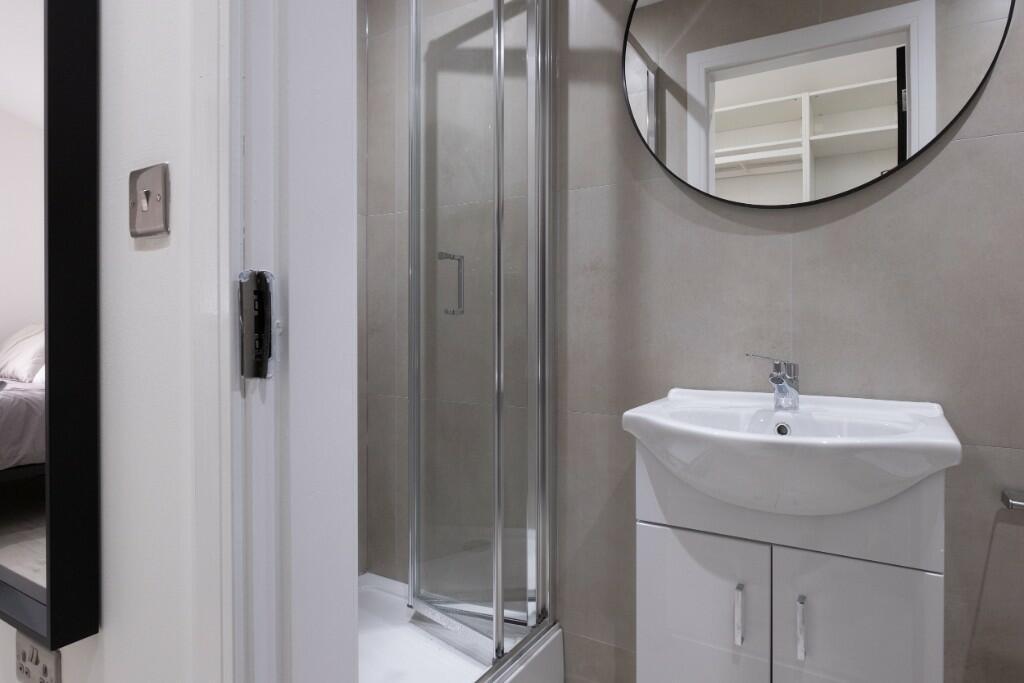Modern bathroom featuring a sleek shower enclos...