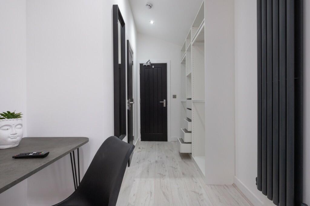 A clean and modern hallway featuring white wall...