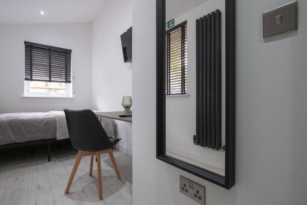 A neat and modern single bedroom featuring a co...