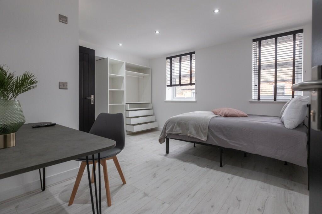 Bright and modern double bedroom featuring ligh...