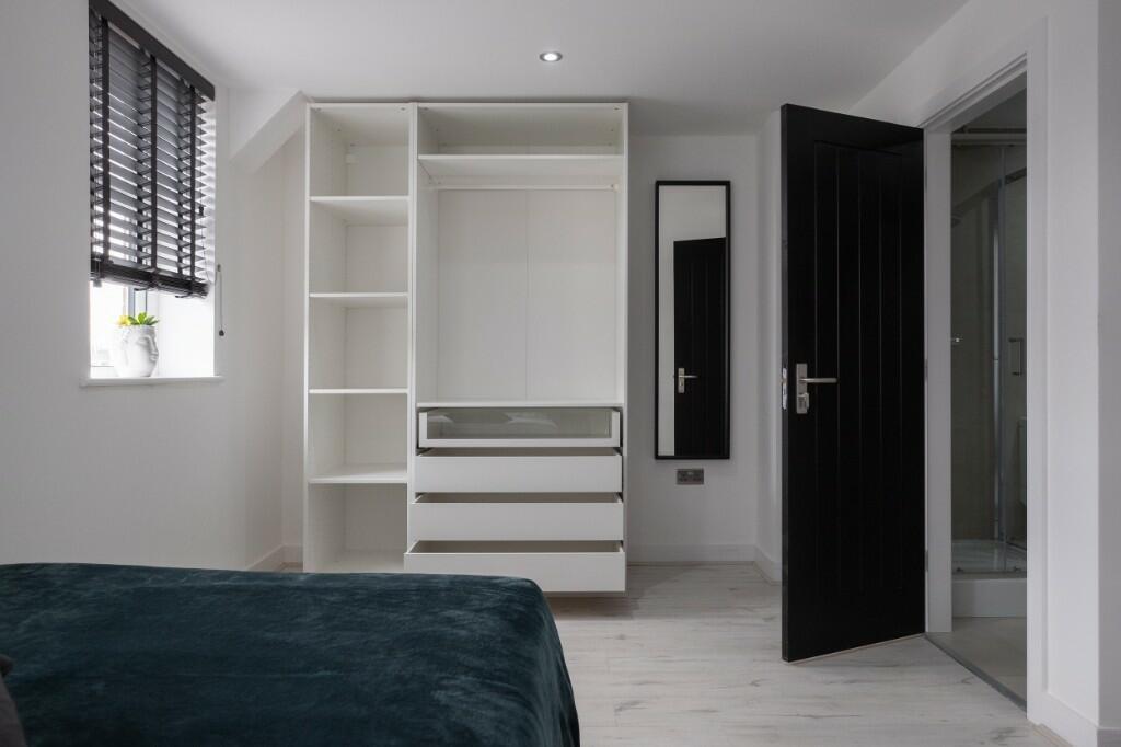 A modern double bedroom featuring a large windo...