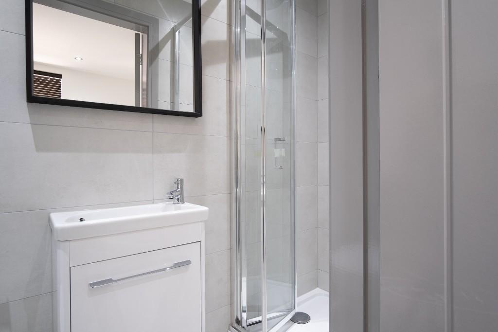 A modern, clean bathroom with a shower enclosur...