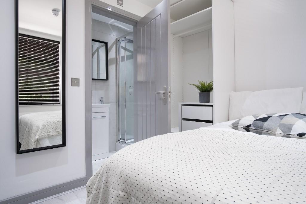 A bright and modern master bedroom featuring a ...
