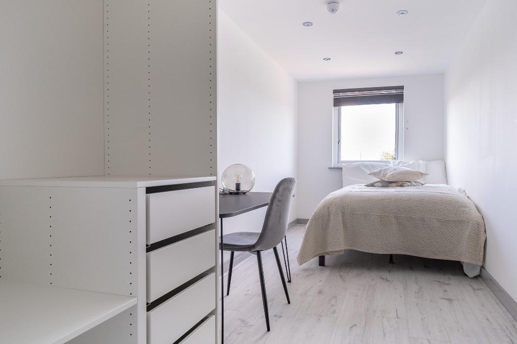 Bright and tidy bedroom with a single bed, a wi...