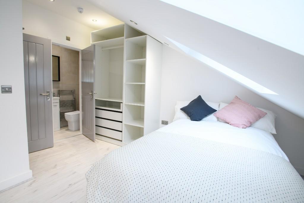 A bright and spacious double bedroom with a com...