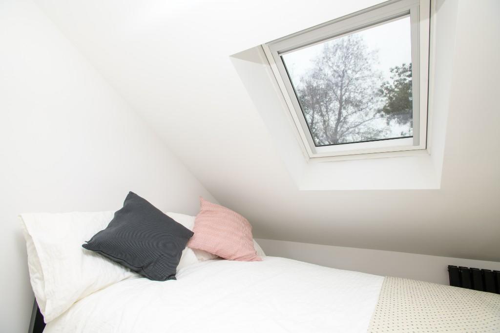 Bright and welcoming bedroom featuring a comfor...
