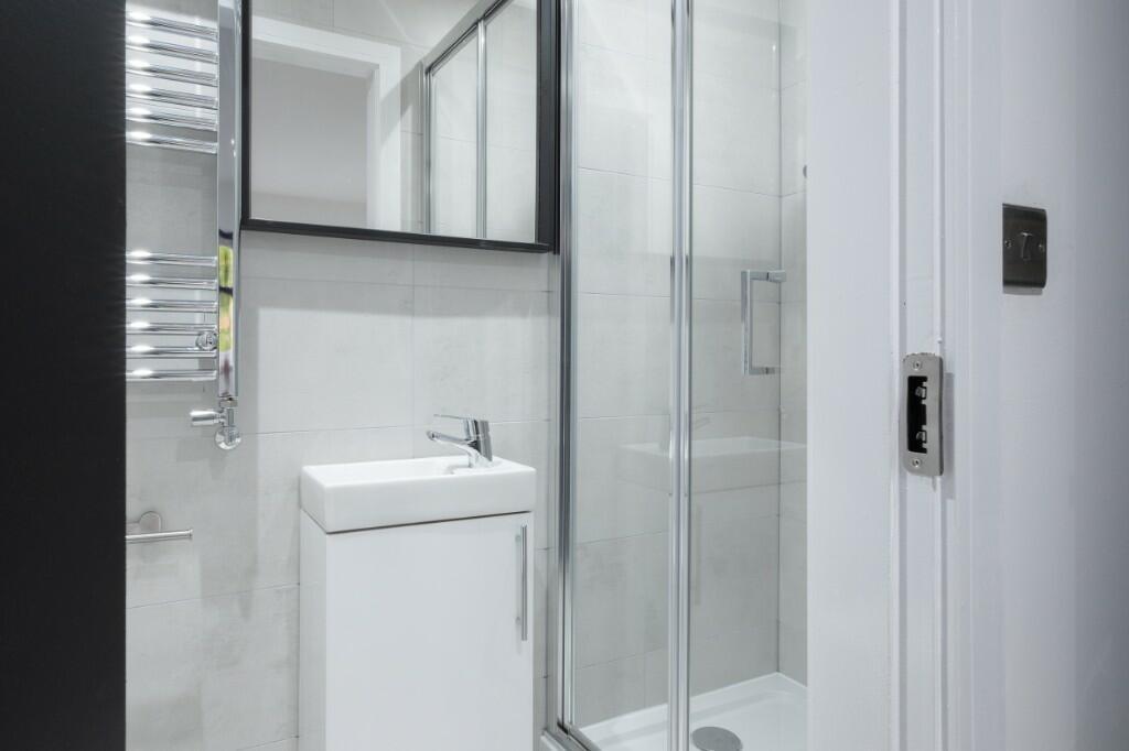 A modern, clean bathroom with a shower enclosur...
