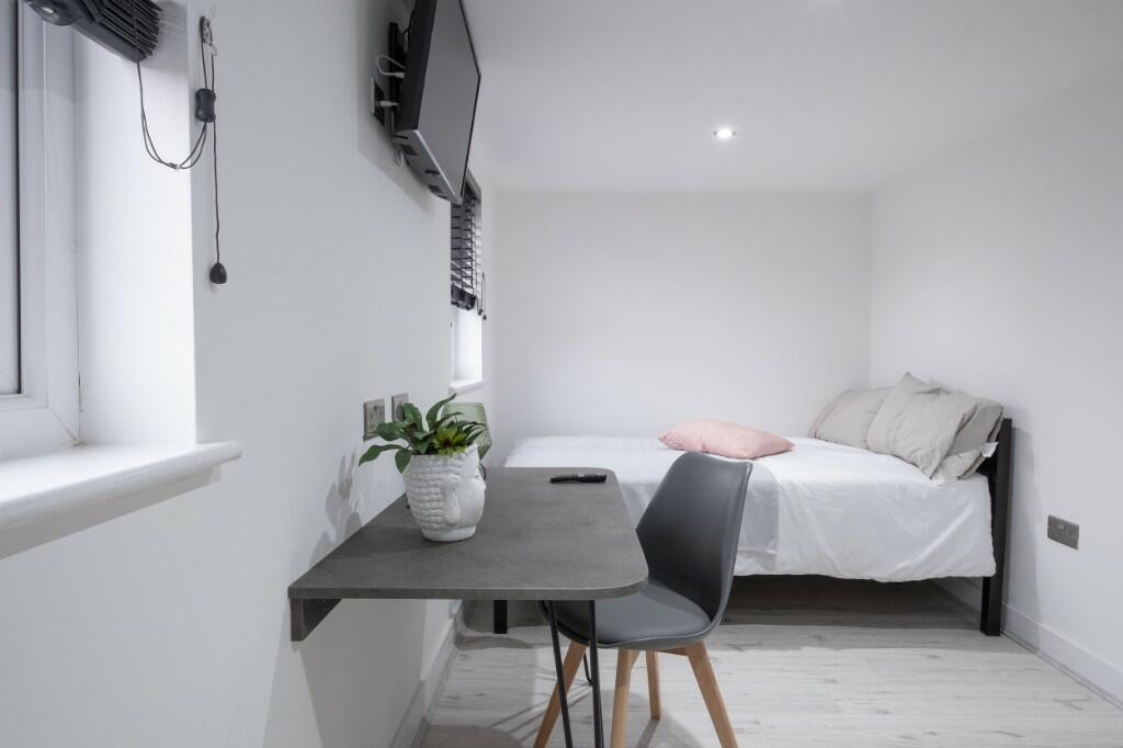 A bright and tidy bedroom featuring a comfortab...