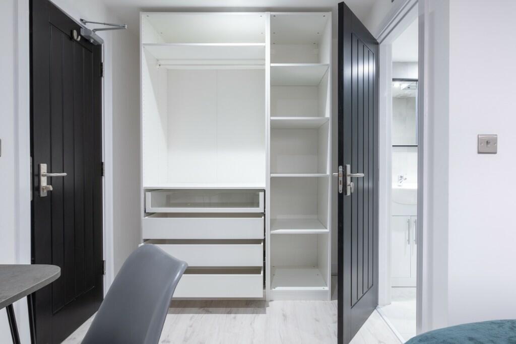 Modern bedroom area with integrated open wardro...