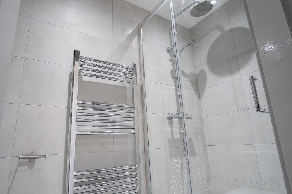 A clean and modern bathroom with a large shower...