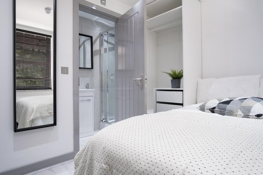 A bright and inviting bedroom featuring a cozy ...