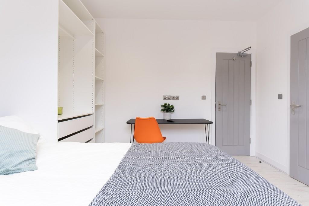 A well-maintained student bedroom featuring a c...