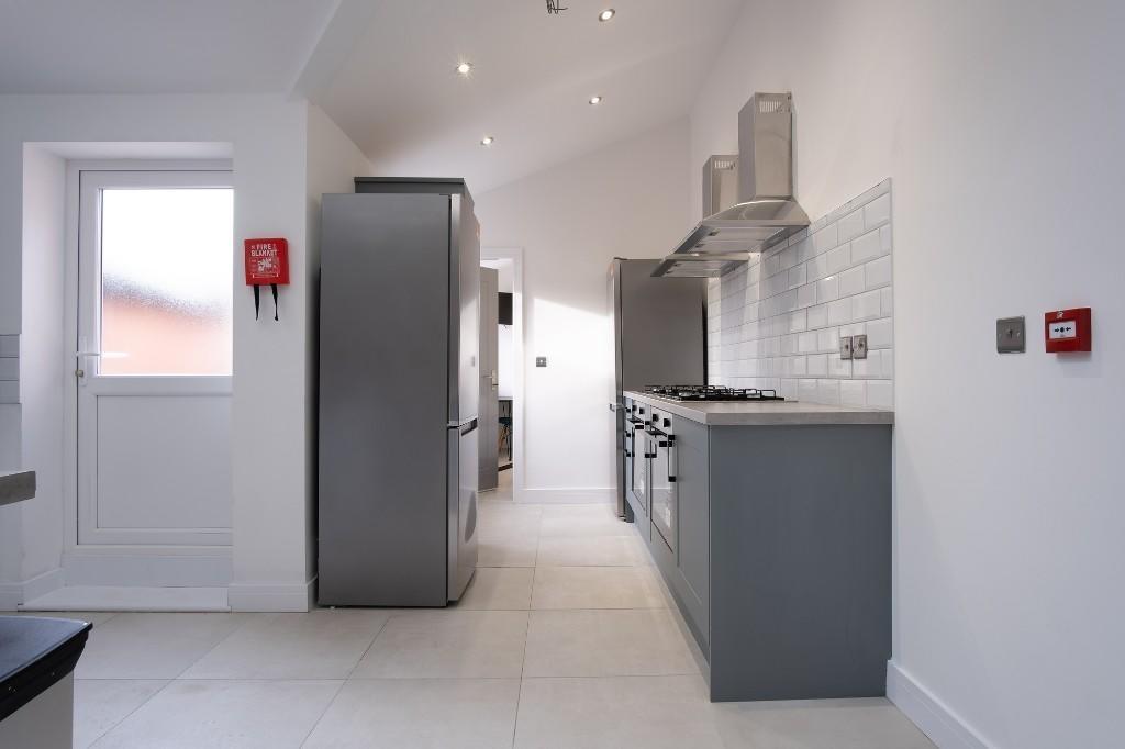Modern galley-style kitchen with grey cabinetry...