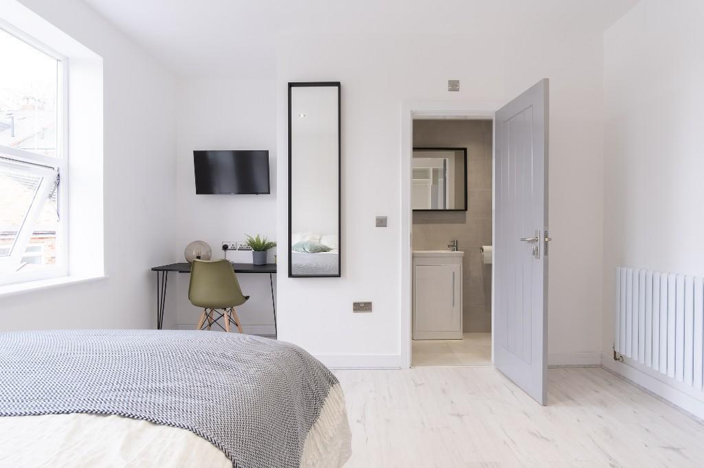 A bright and tidy bedroom featuring natural lig...