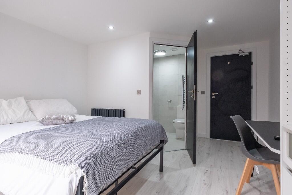 A spacious and clean bedroom featuring a double...