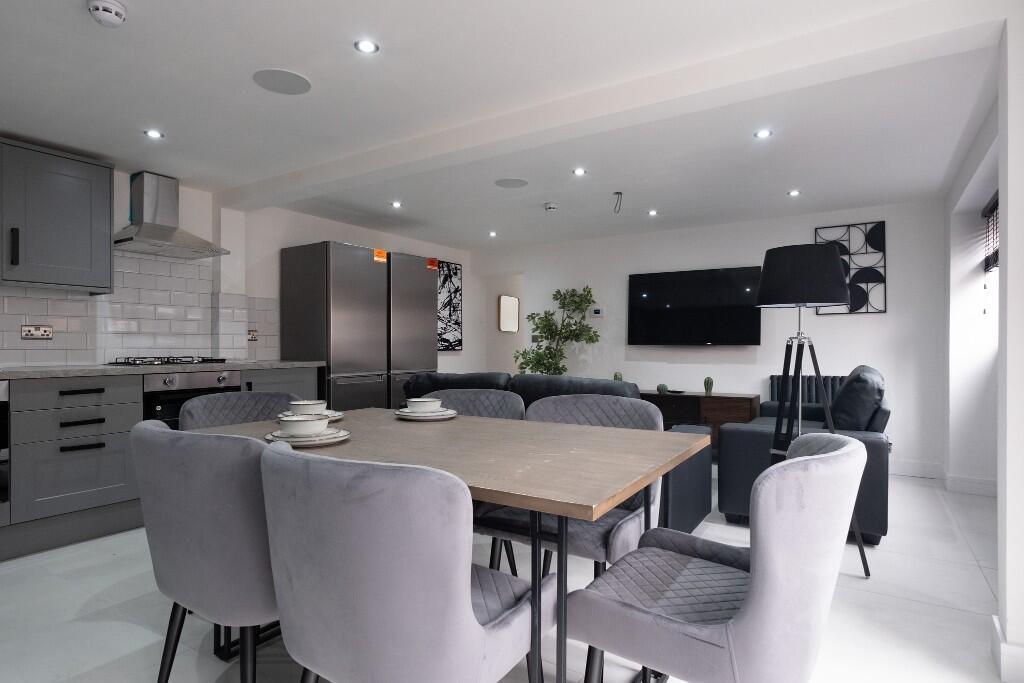 A spacious and modern living room featuring amp...