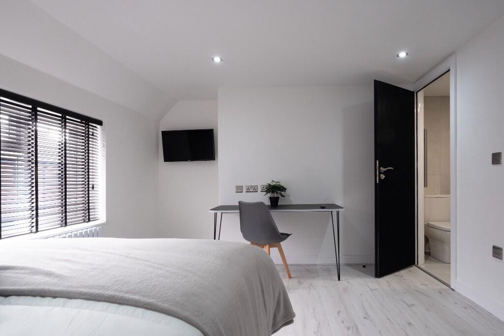A bright, modern bedroom with spacious layout, ...